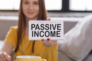 Person holding a notepad with "Passive Income" written in bold, emphasizing the concept of earning income passively