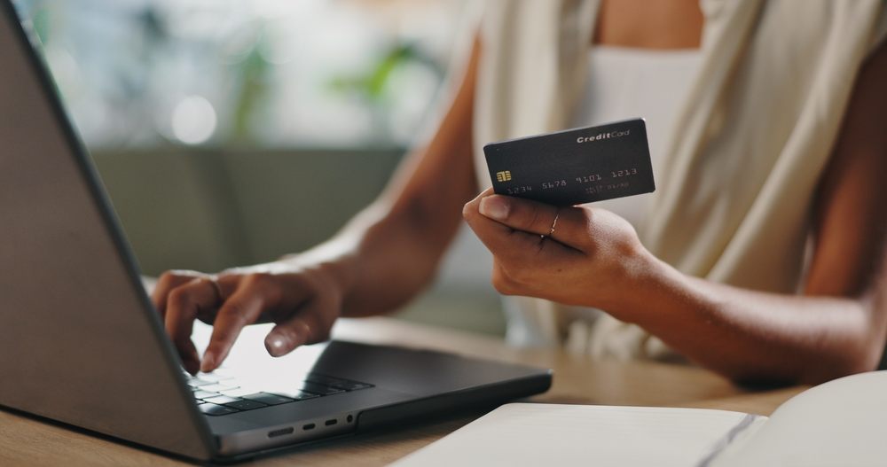 Person applying for a back-to-school loan online using a credit card and laptop with Loan Express