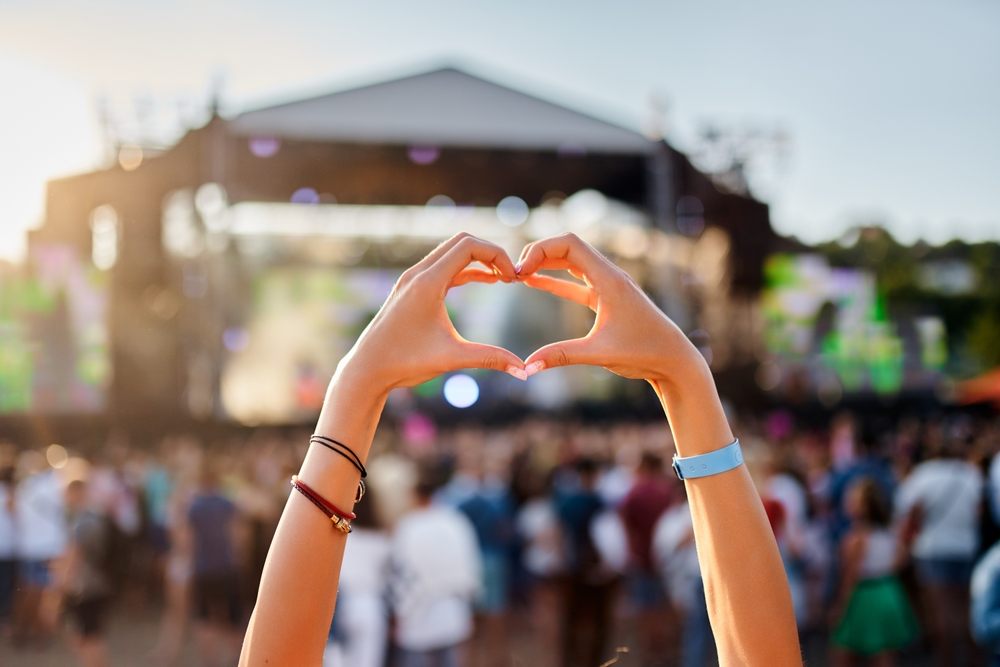Fan forming a heart with hands at an outdoor concert after covering ticket costs with a payday loan in Canada