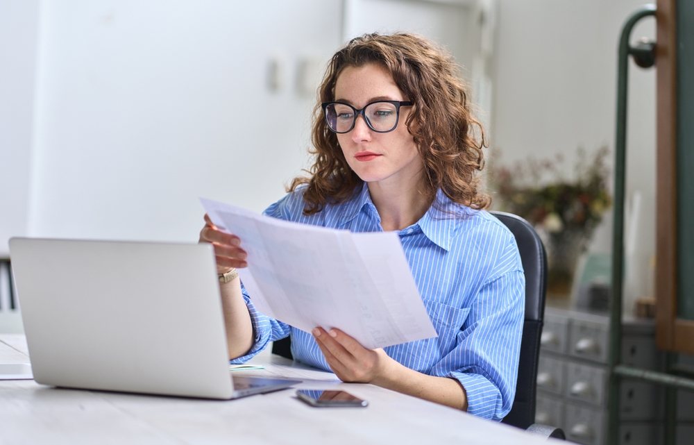 Woman reviewing her credit report at home on a laptop