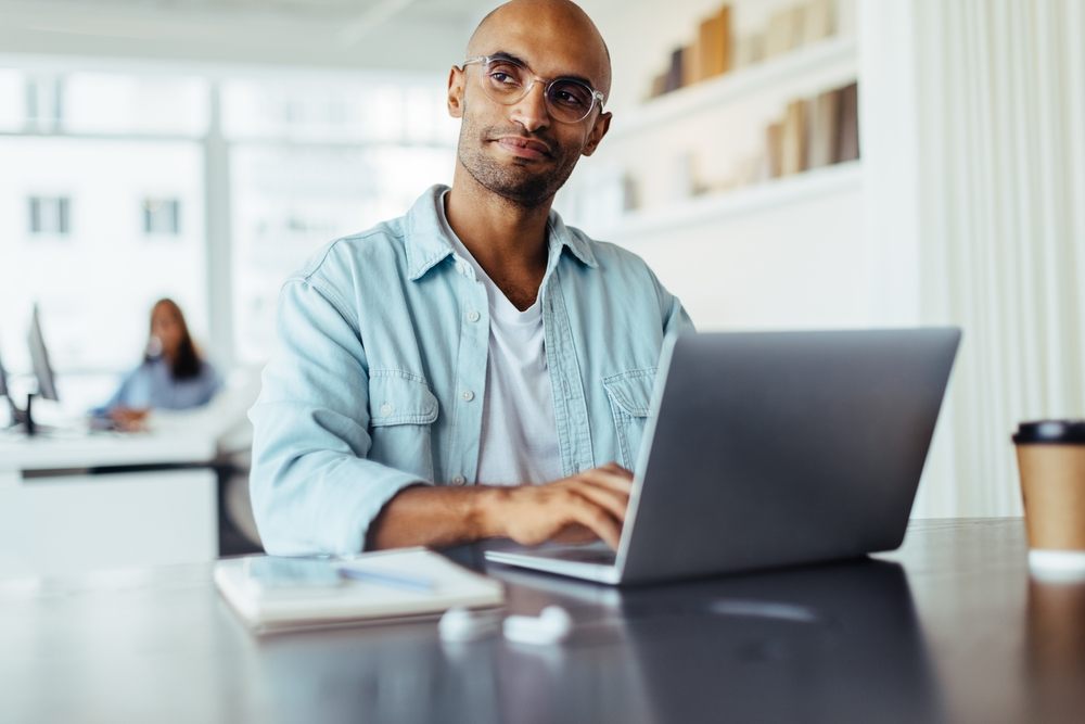 Man using laptop in office, representing fast tech and gadget loans in Canada from Loan Express.
