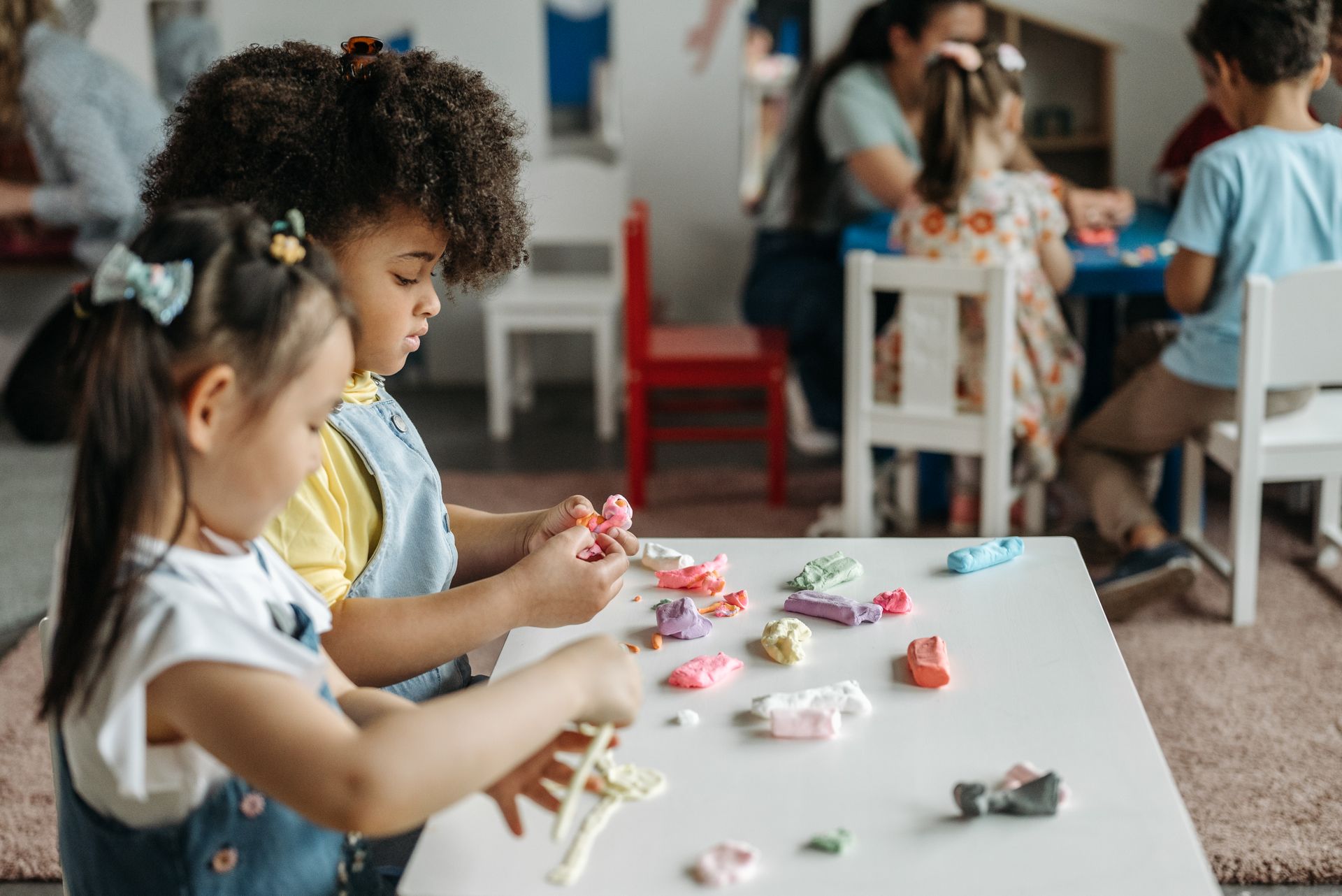 Kids at a daycare table playing with colorful clay